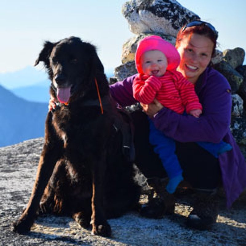 Dr. Meryl Herberts, Emergency Veterinarian at Boundary Bay Veterinary Specialty Hospital, outdoors on a mountain with her dog and baby